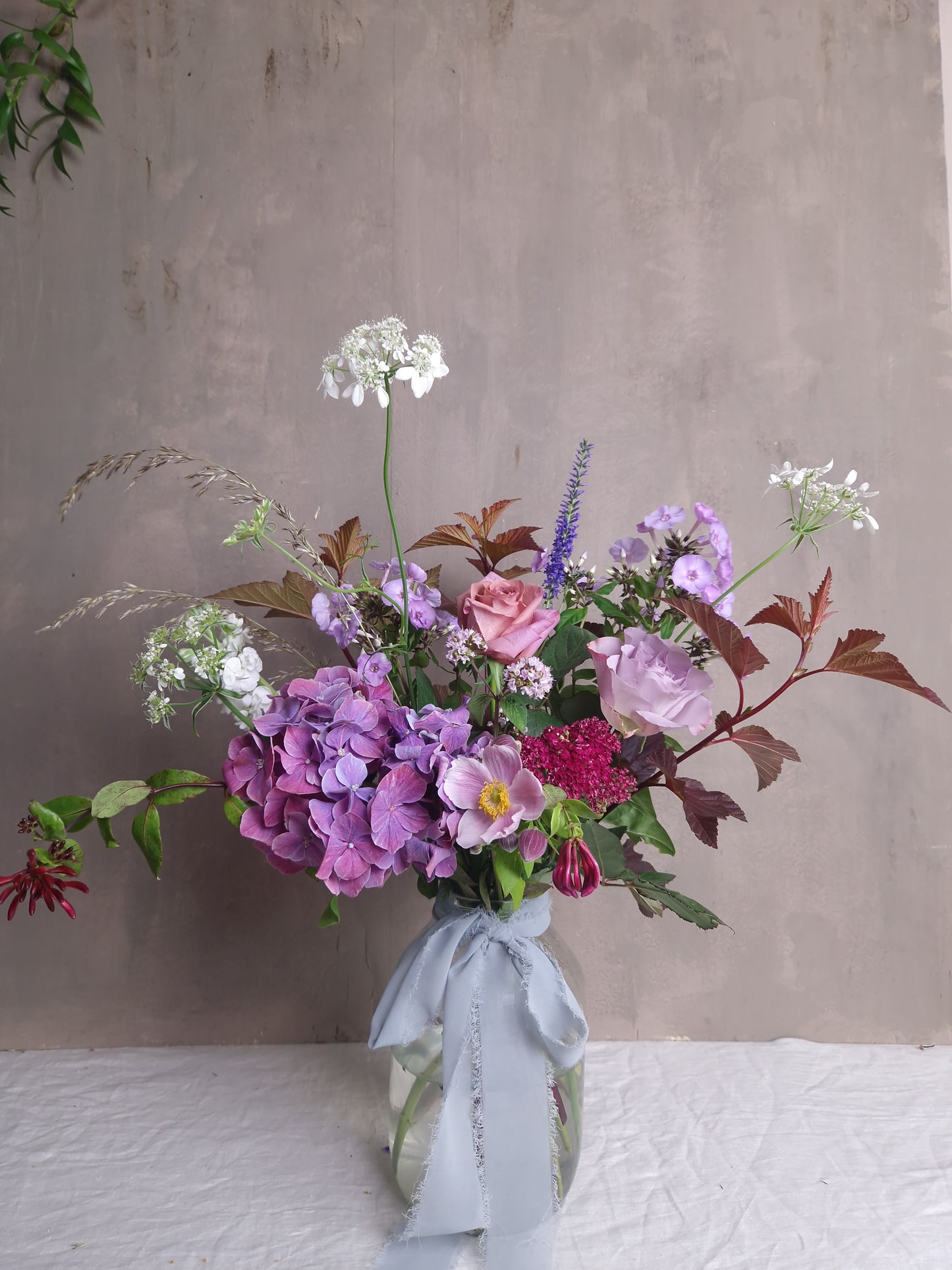 Pink and purple florist choice arrangement in jar with water